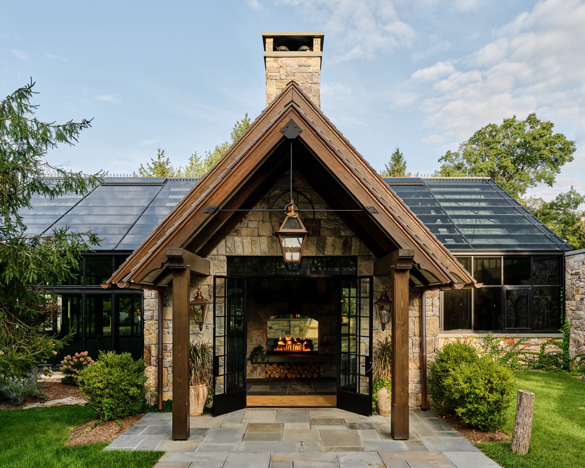 The Glasshouse entry gable in daylight, the fire lit inside