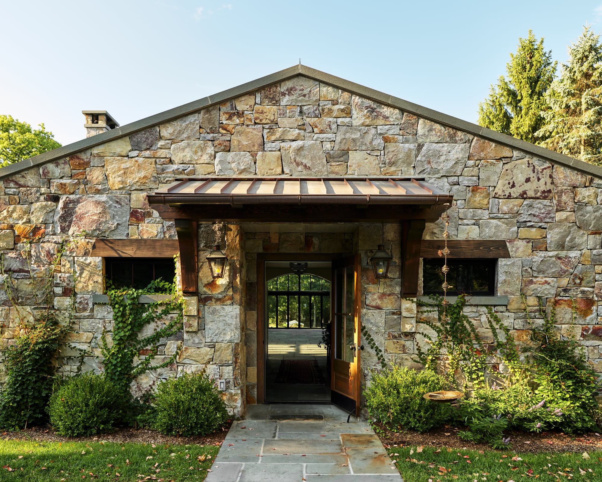 The rear porch: a shed roof on timber brackets over the stone entry