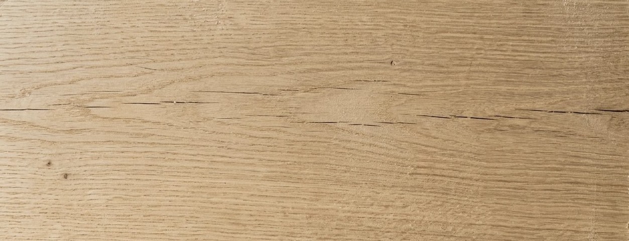 The pale face of a white oak timber, a fine check running along the grain
