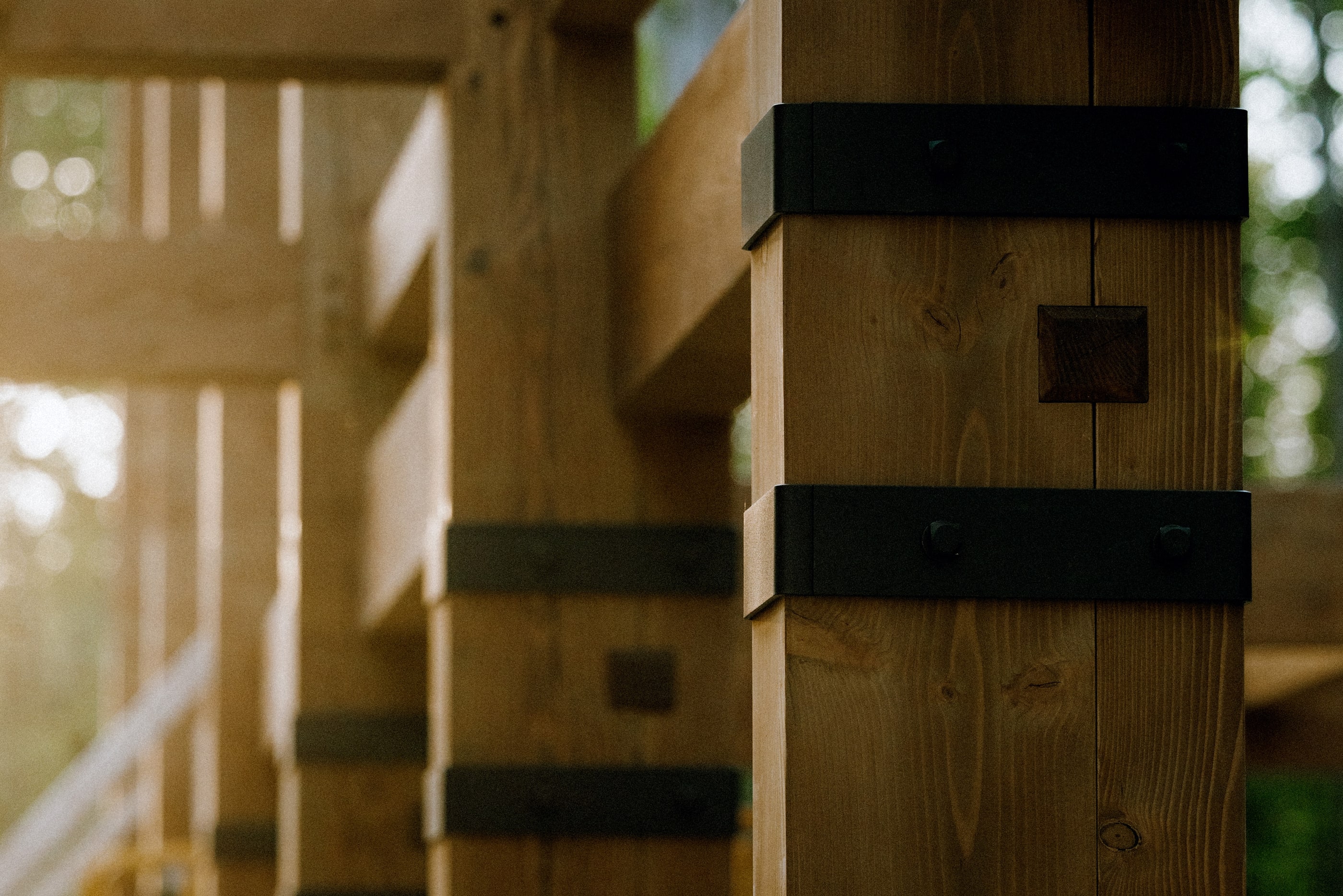 Steel strap brackets down a row of king post bents, warm evening light