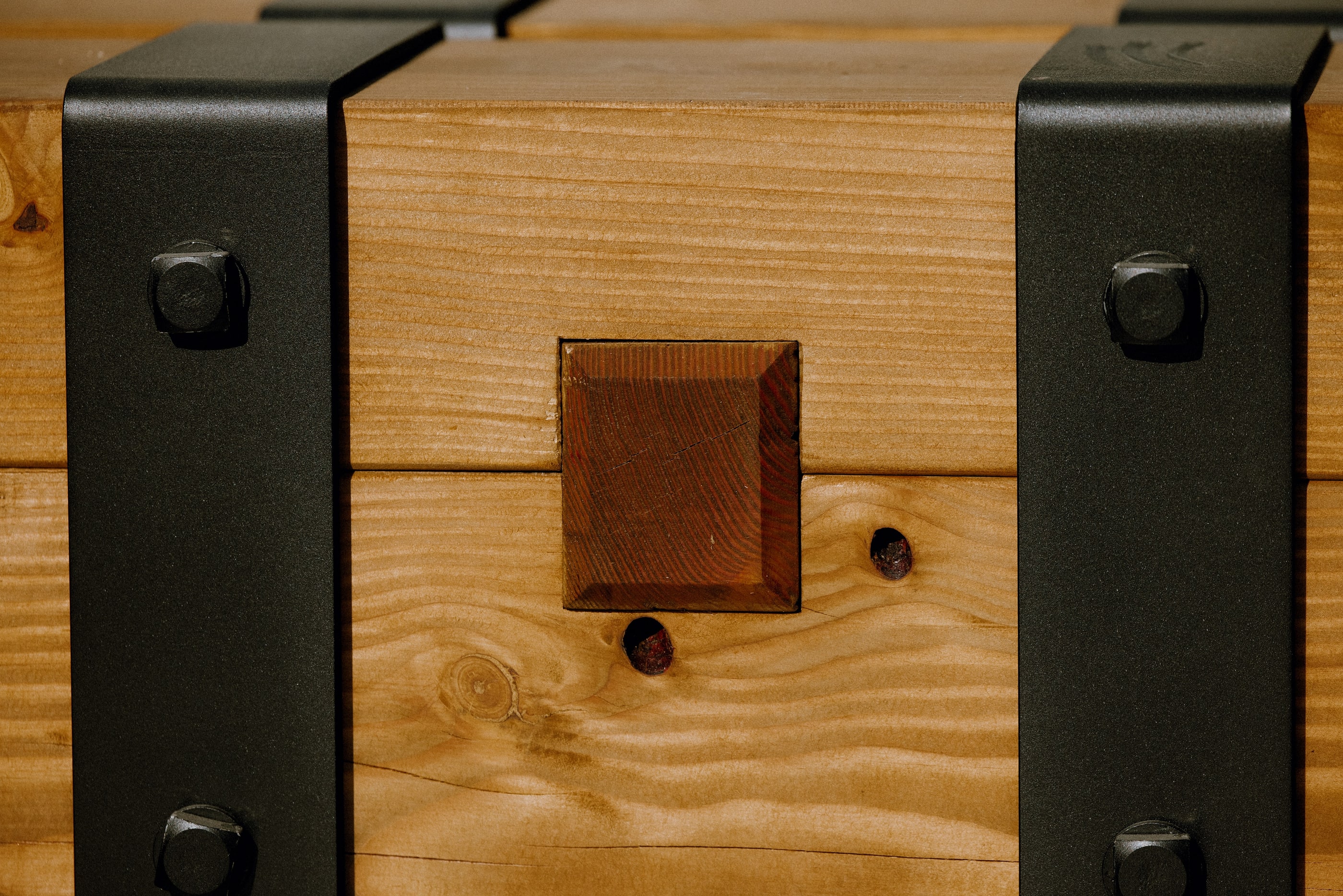 A mortise and bolt between two steel strap brackets, close detail