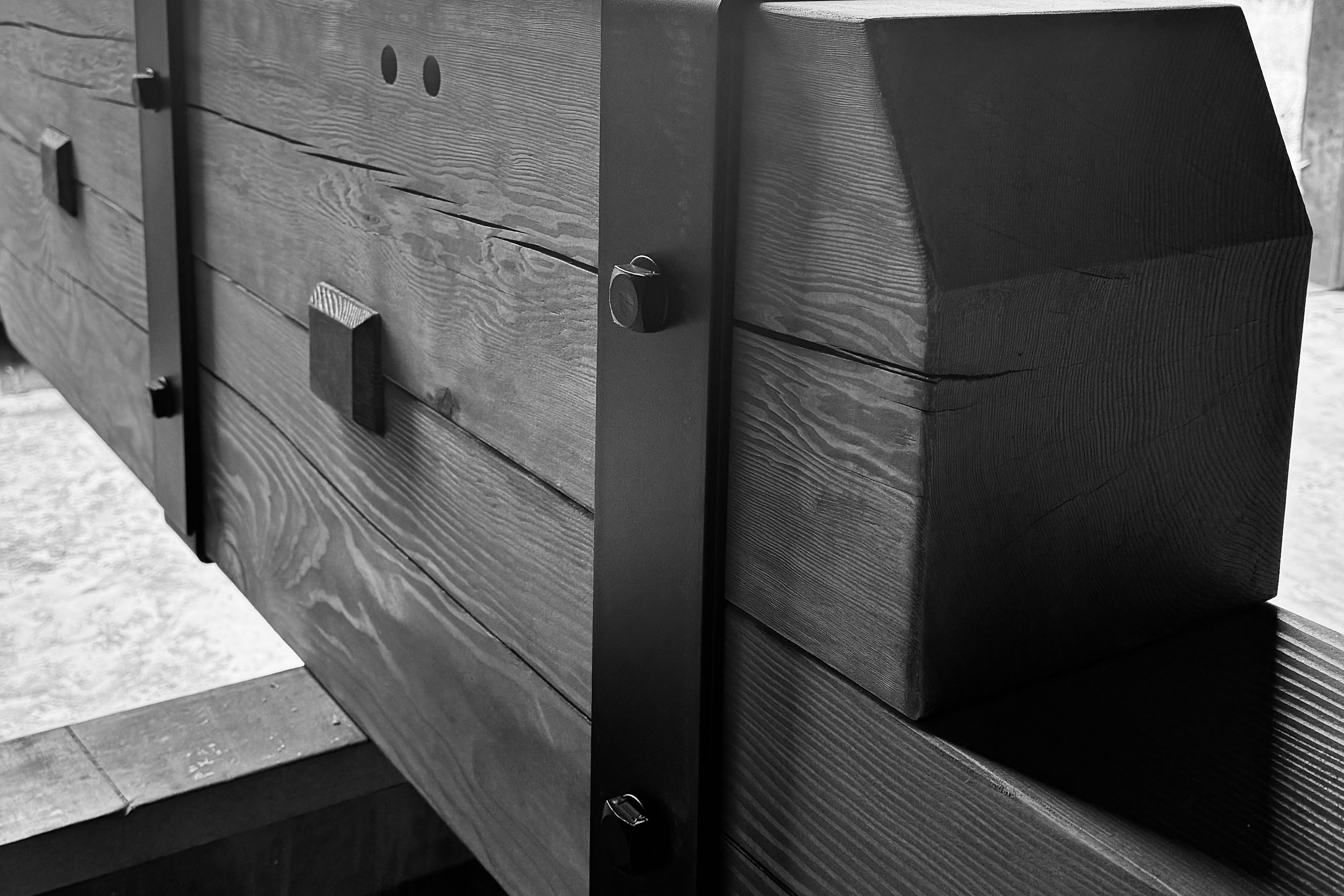A fabricated post end and steel bracket connection, photographed in the shop, black and white