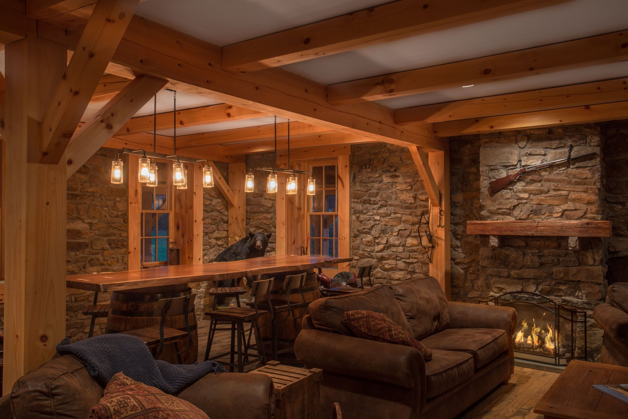 The bar room: pine posts, beams and braces inside the stone walls, a fire lit at the hearth