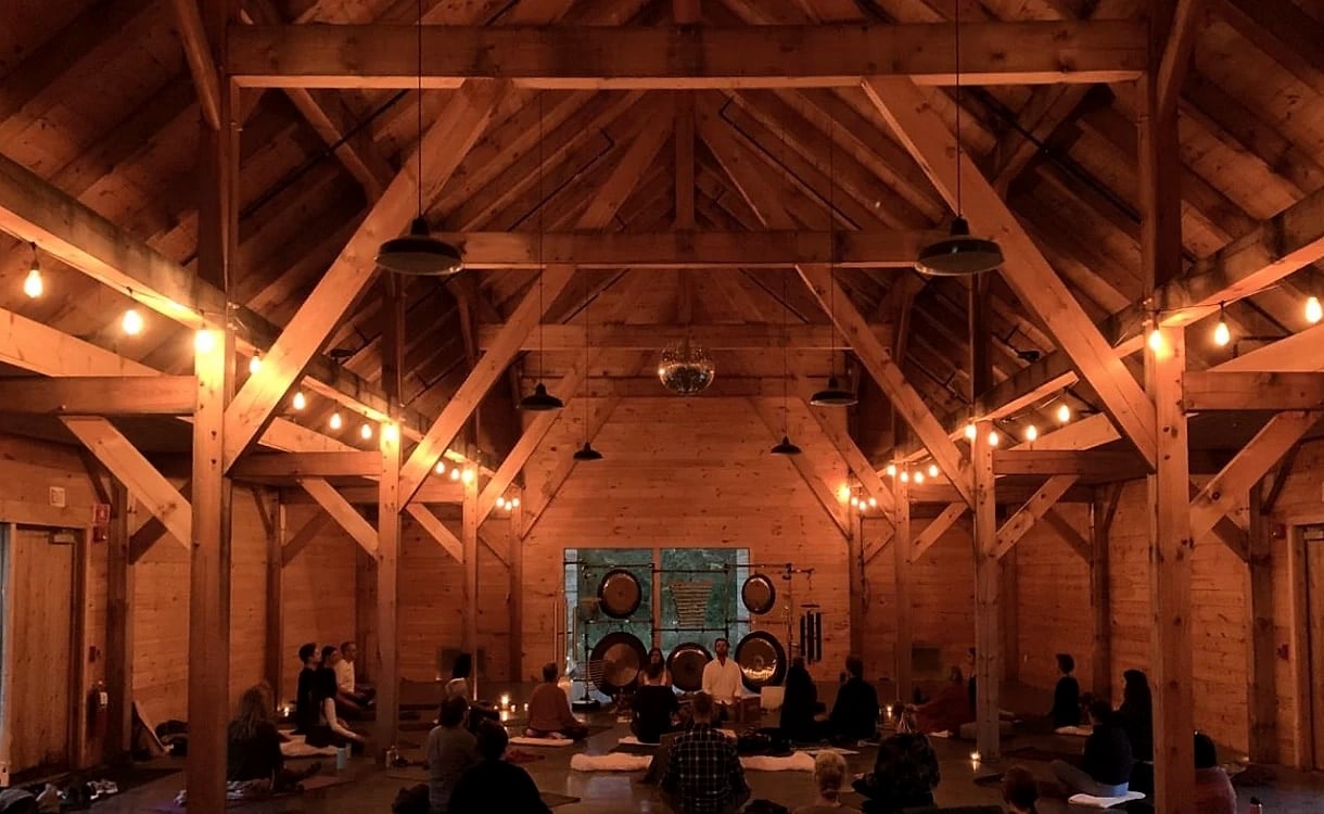 The finished barn at night, string lights overhead and a sound bath underway