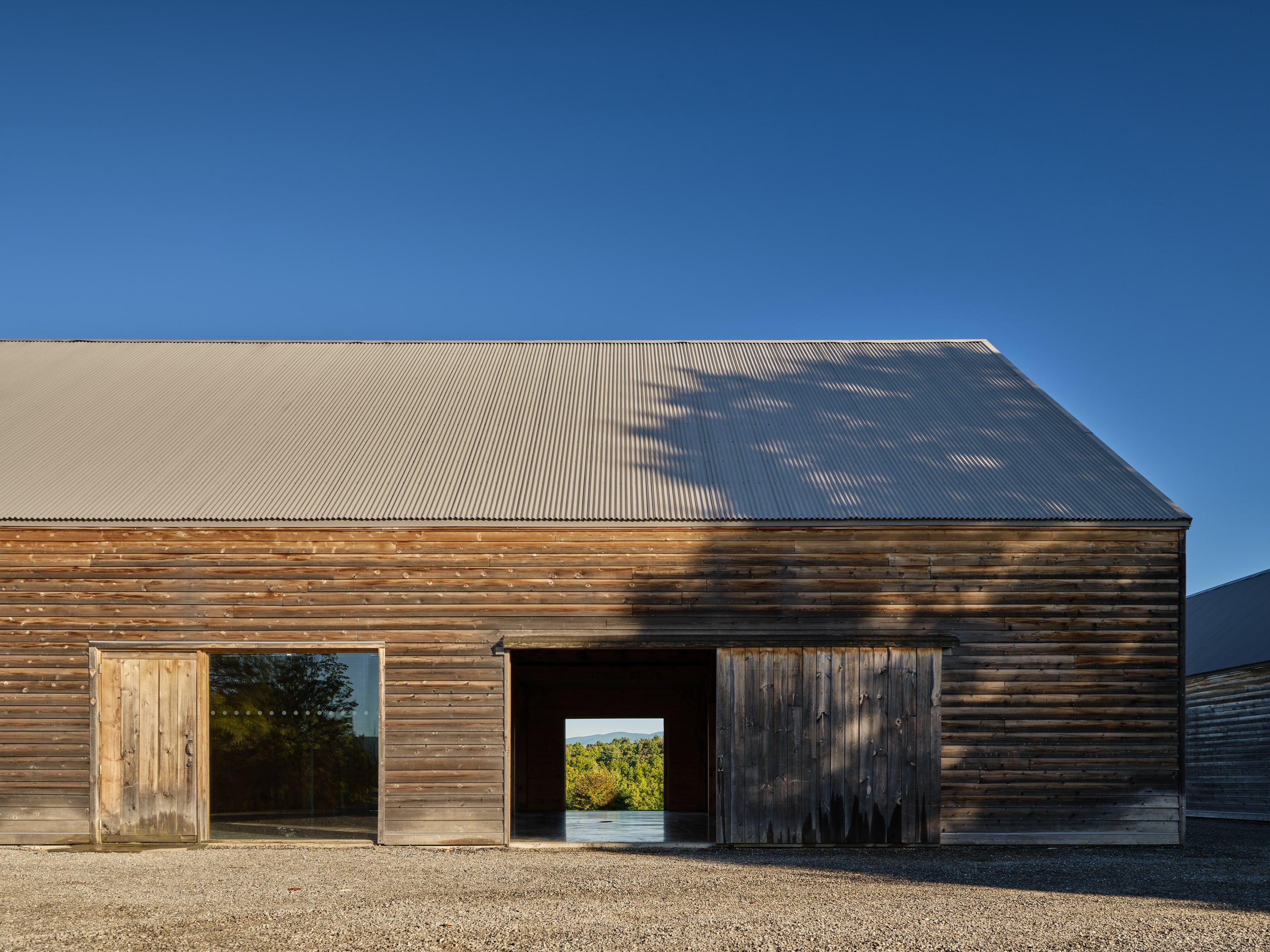 The barn in morning sun, its big doors rolled open and the Catskills framed through the far doorway