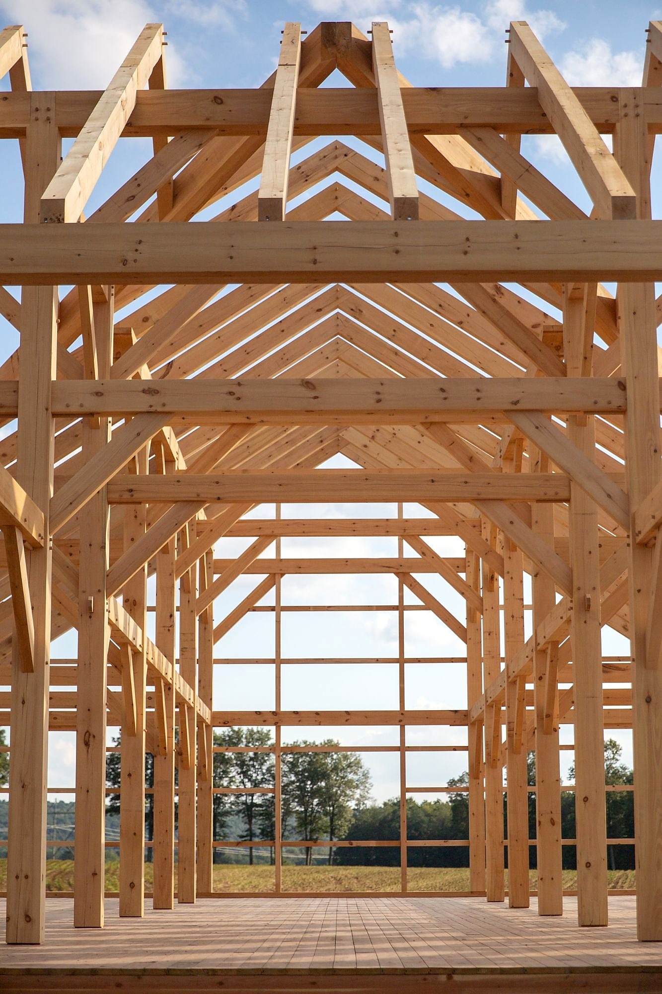 Looking down the length of the frame toward the gable window, open farmland beyond