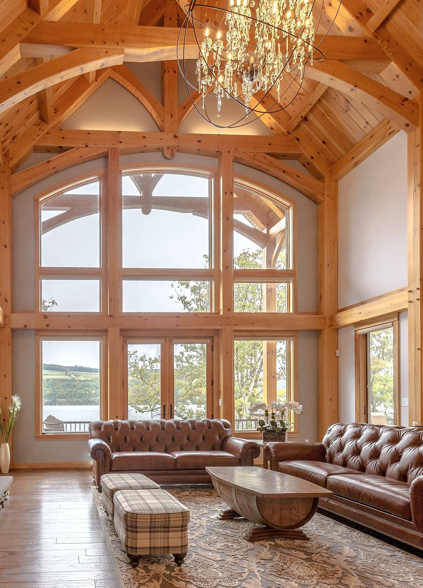 Curved-chord trusses rising over the arched window wall, chandelier hung from the ridge