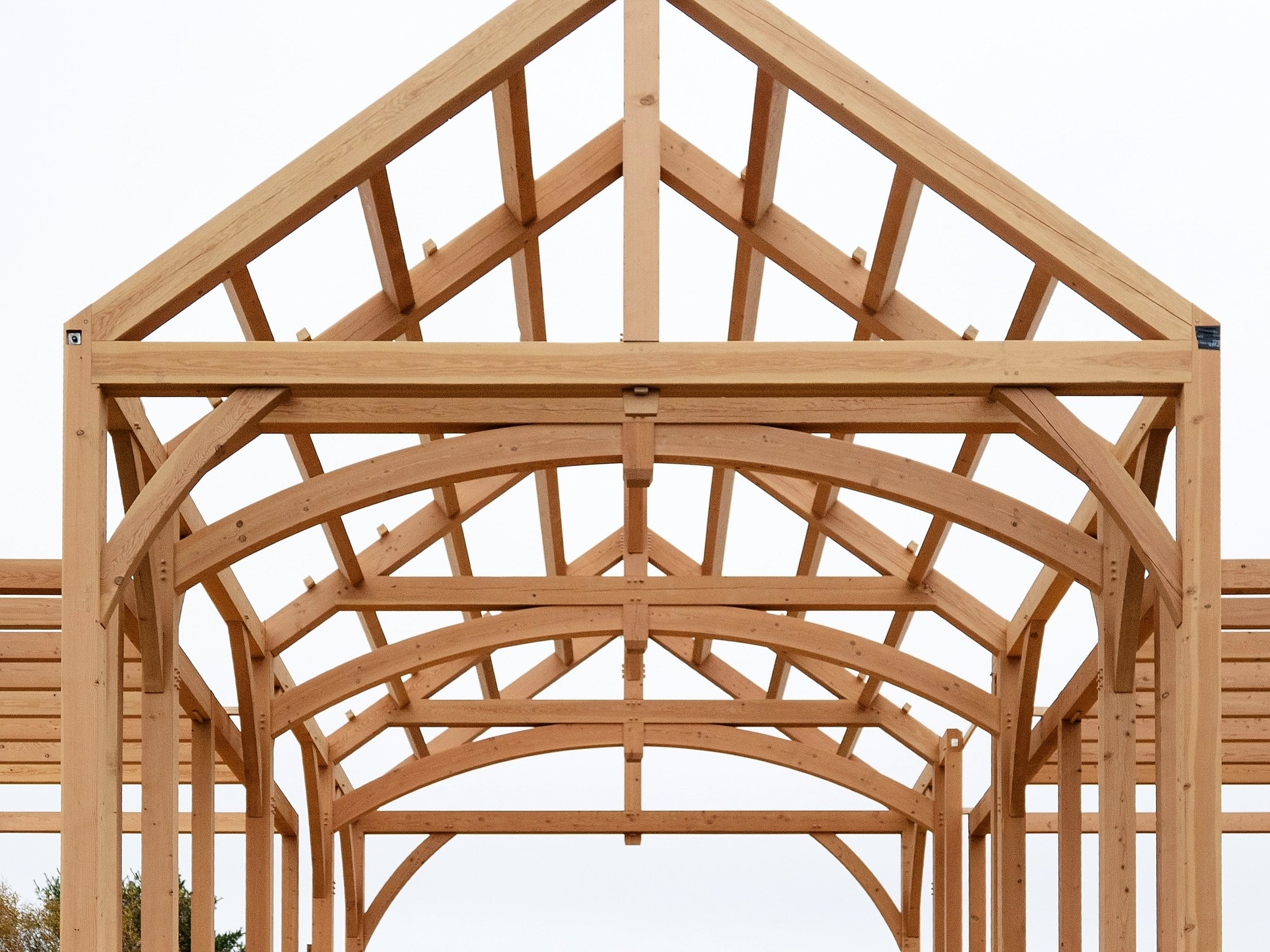 The great room’s arched trusses, straight on, against an overcast sky