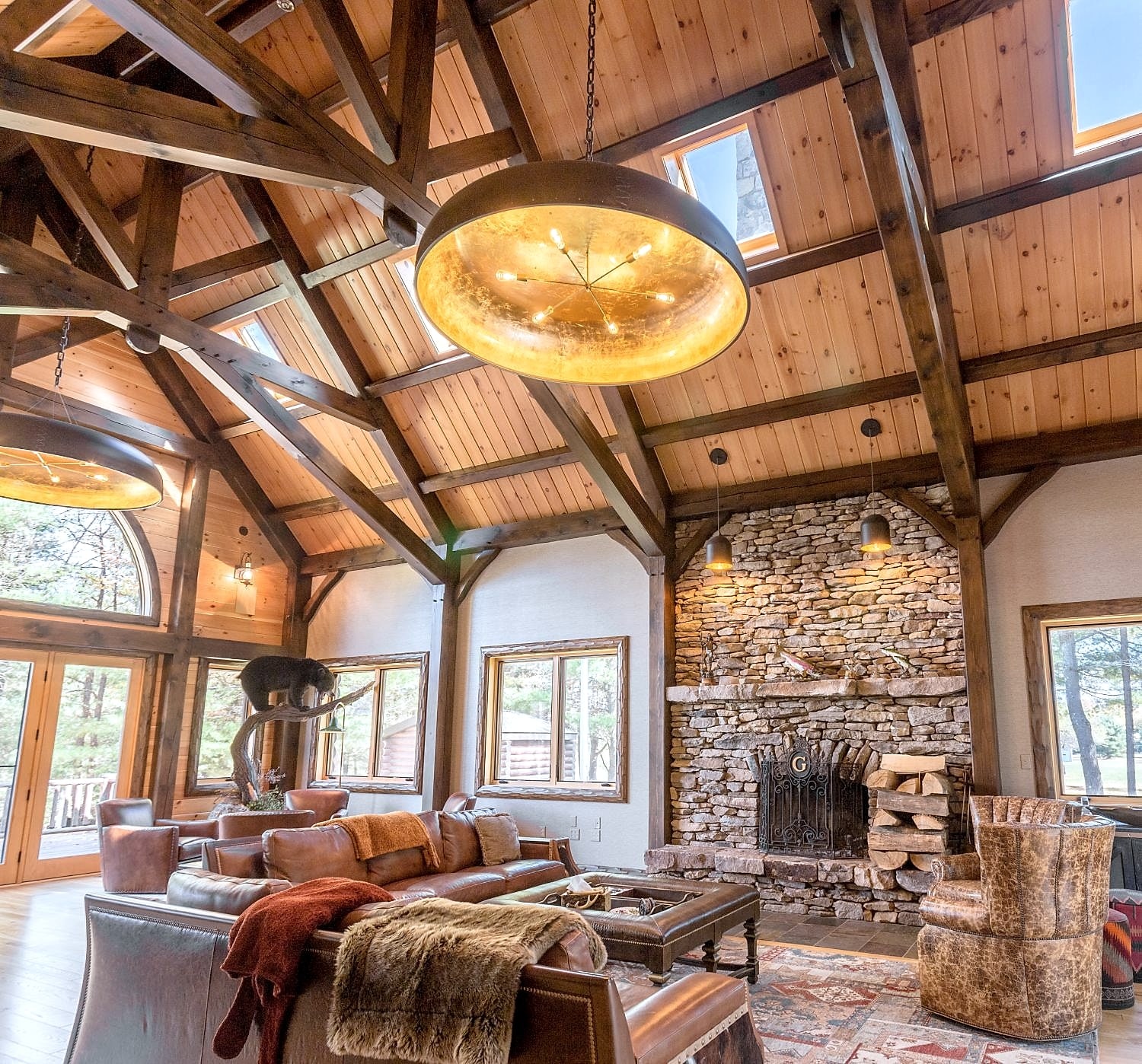The great room from the seating, toward the stone fireplace under the trusses