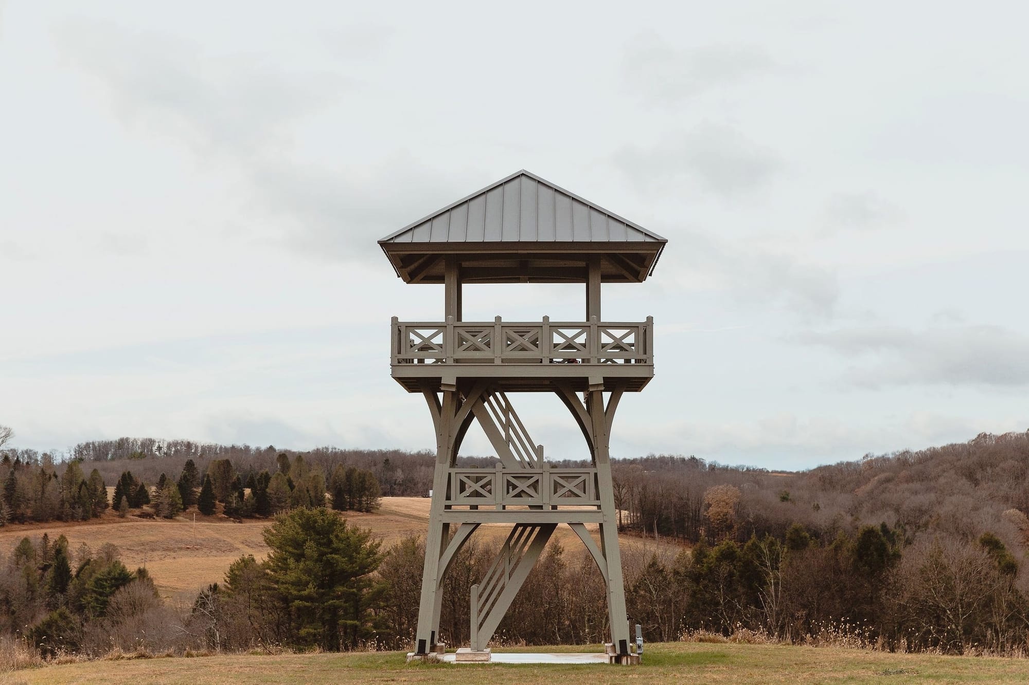 The tower from the front on its hilltop, the stair rising through its middle, fields and wooded hills behind