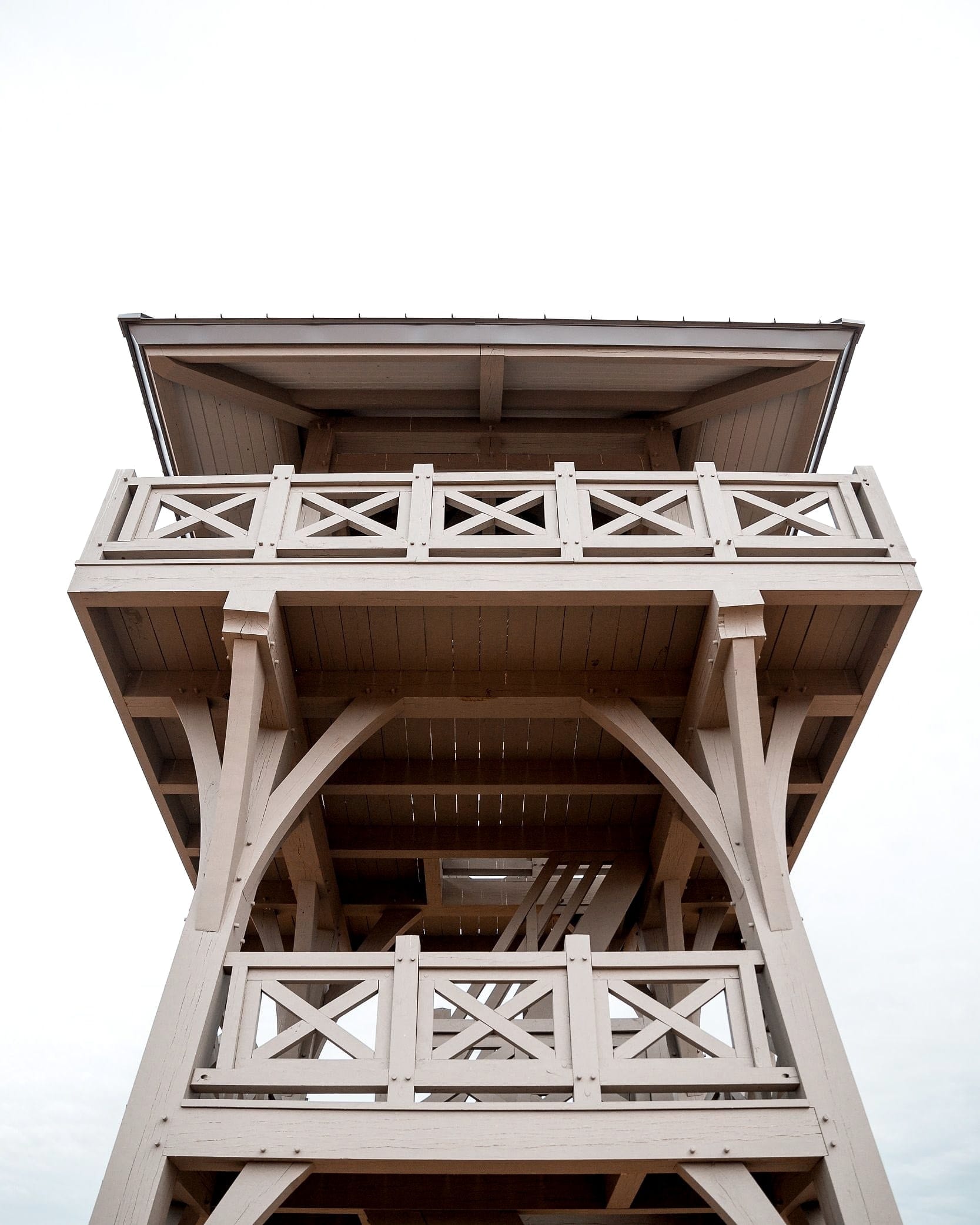 Looking straight up the tower: the landing, the top platform, the curved braces and the stair between them
