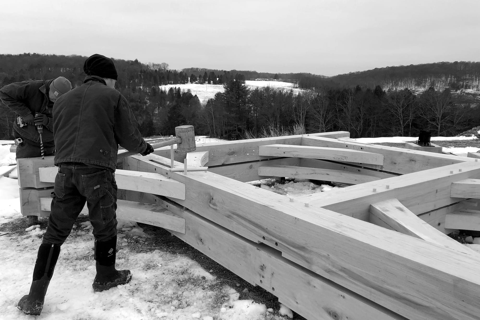 Assembling a bent on the ground in the snow, black and white
