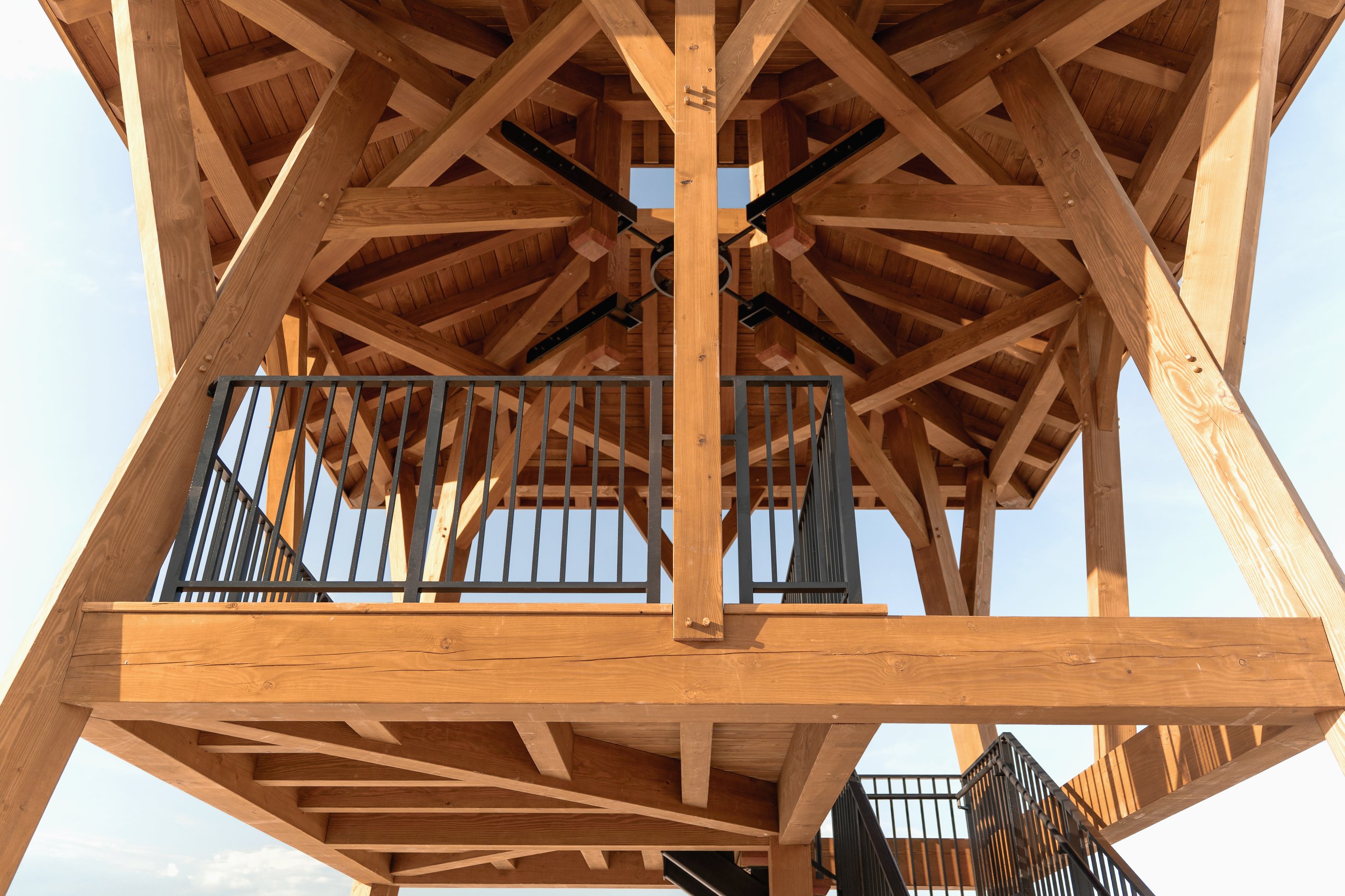 Looking up into the finished roof: dragon beams meeting the steel tension ring, jack rafters radiating