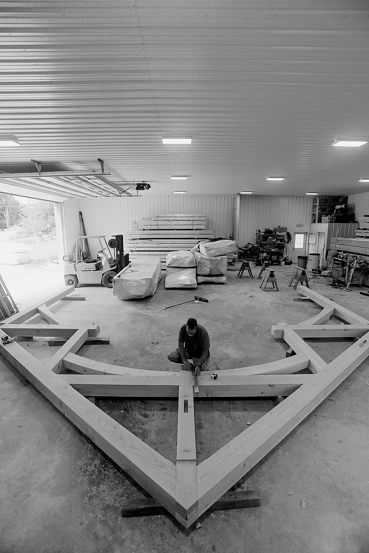 Greg squaring a truss laid out on the shop floor