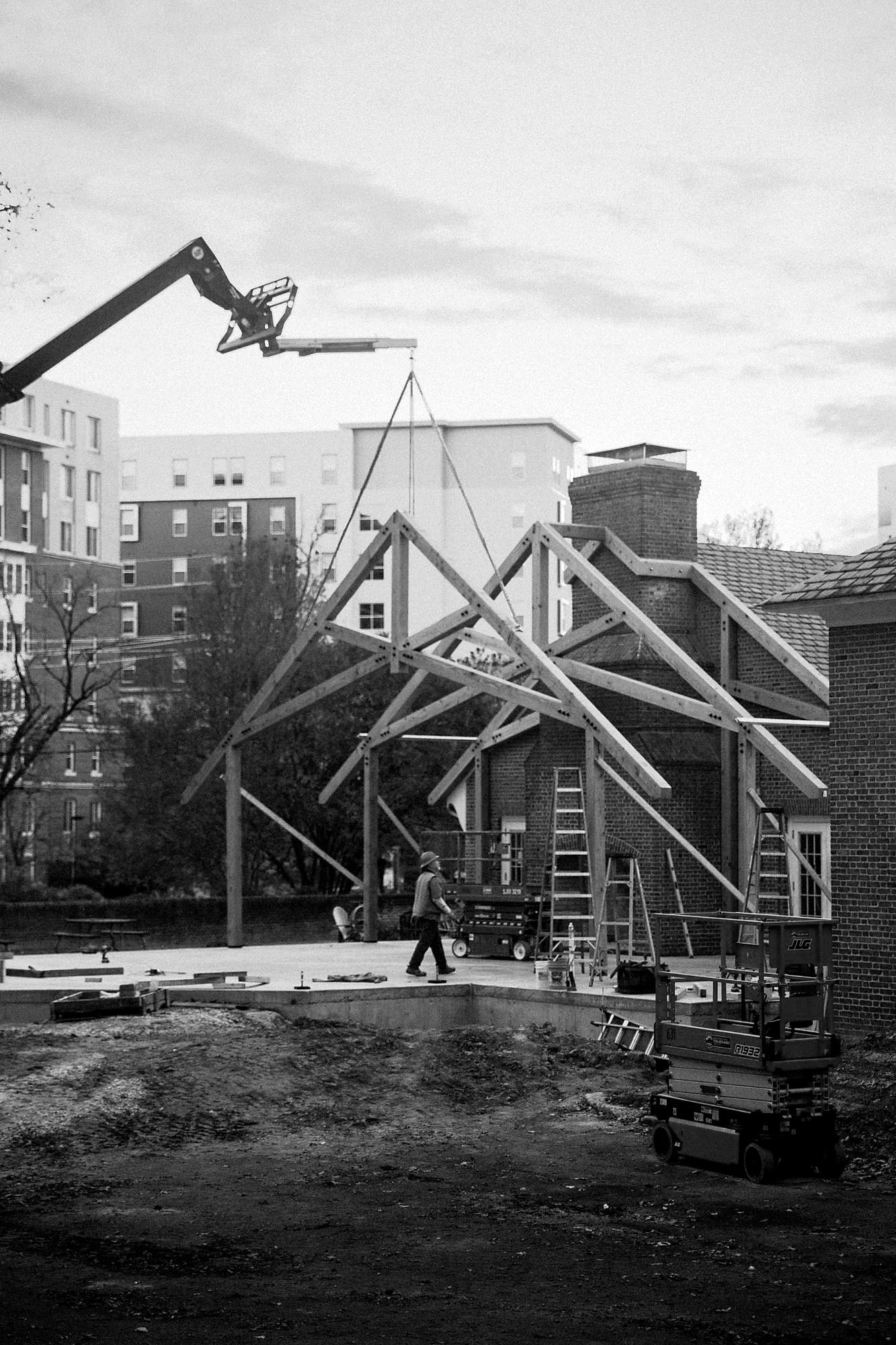 A telehandler setting a truss on the University of Maryland job, apartments behind