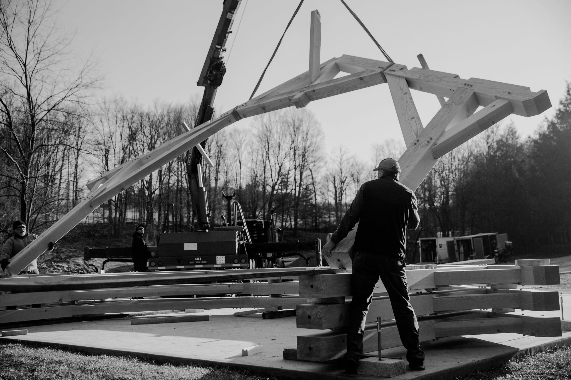 The crew guiding a bent as the crane lifts it off the stack, black and white